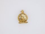 a gold plated pocket watch with a bird on it
