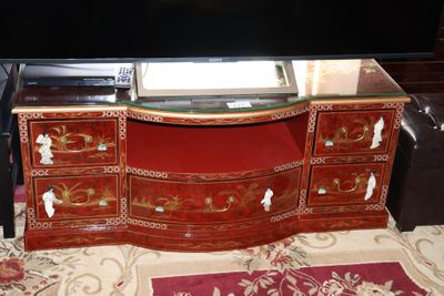 a large television on a stand with a glass top