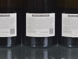 three bottles of wine are lined up on a glass table