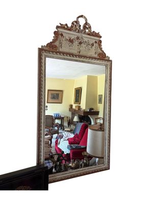 un miroir dans lequel se reflète un salon avec un fauteuil rouge