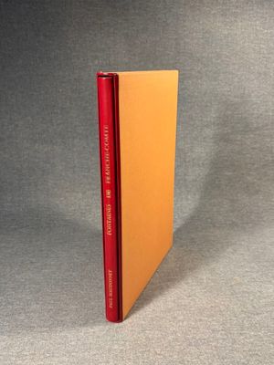 an orange book sitting on top of a table next to a gray background