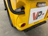 a close up of a yellow vehicle with a sticker on it