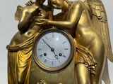 une horloge en or ornée d'un ange et d'un oiseau