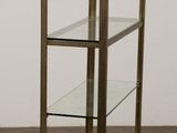 an image of a glass and brass bookcase on a parquet floor