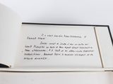 an open book with writing on it sitting on a table