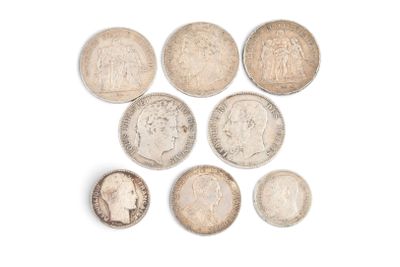six types différents de pièces d'argent sur une surface blanche