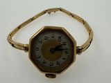 an image of a gold wrist watch on a white surface