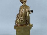 an image of a bronze statue of a woman sitting on a box