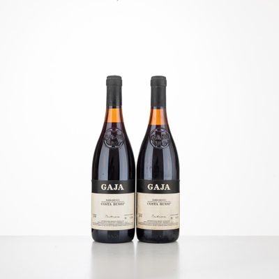 two bottles of wine sitting on top of a table next to each other