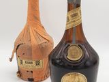 two bottles of liquor sitting next to each other on a white surface