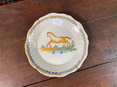 a plate with a horse painted on it sitting on a table