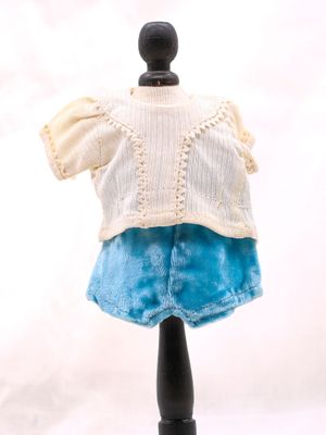 un pull blanc et une jupe bleue sur un mannequin