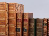 several old books are stacked on top of each other in a row