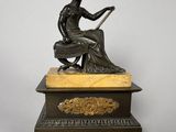 an antique bronze statue of a woman sitting on top of a marble base