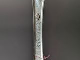 a spoon with a face on it sitting in a persons hand
