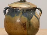 a brown and blue pot with handles on a table