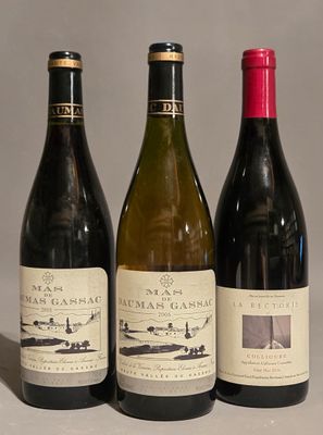 three bottles of wine are lined up on a table