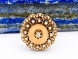 Gros plan sur une bague en or ornée de perles
