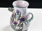 a small vase with a floral design on it on a table
