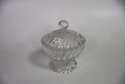 un bocal en verre muni d'un couvercle, posé sur une surface blanche