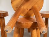 a person that is standing next to some wooden stools