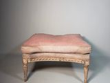 un vieux banc sur lequel est posé un coussin rembourré rose