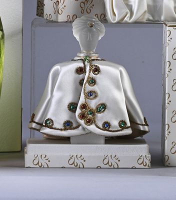 a figurine of a woman in a white dress on a shelf