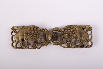 une paire de boucles anciennes en laiton représentant des éléphants, sur fond blanc