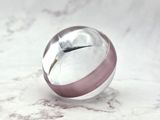 a glass ball with a clock inside of it on a marble surface