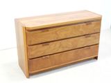a wooden chest of drawers with three drawers on it