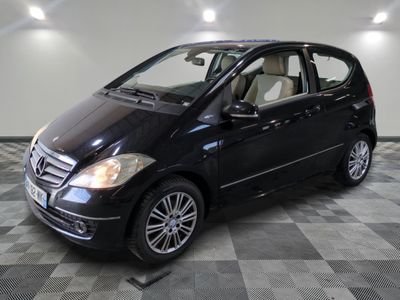 une photo d'une mercedes noire de classe b garée sur un sol en damier