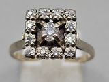 a close up of a diamond ring on a white surface