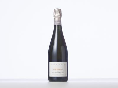 une bouteille de vin posée sur une table blanche