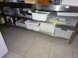 a kitchen with a stainless steel counter and a metal shelf