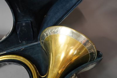un instrument à vent en laiton dans un étui, avec un miroir en arrière-plan