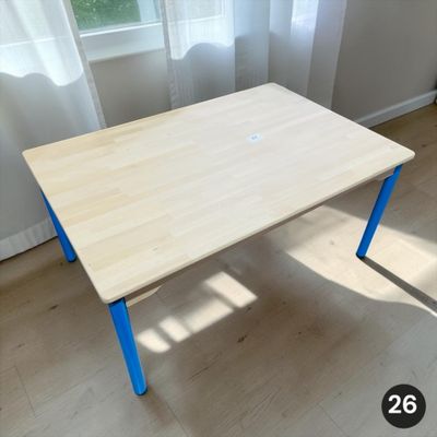une table en bois aux pieds bleus dans une pièce