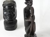 three wooden statues of a man and a woman on a white surface