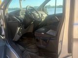 une portière de voiture ouverte, avec le siège conducteur rabattu