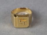a gold ring with a cross on it sitting on a table