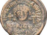 une pièce de monnaie ancienne sur laquelle figurent le buste d'une femme et une croix