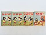 three mickey mouse books are lined up on a white surface