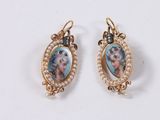 a close up of a pair of earrings with pearls on them