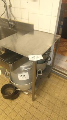 a kitchen with a sink and a trash can on the floor
