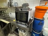 a kitchen with a microwave and a trash can in it