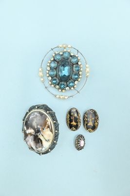 three pieces of jewelry including a broochle, earrings, and a ring