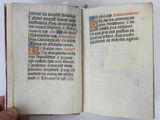 someone is holding a book in their hand on a white surface