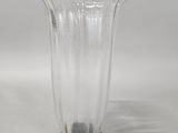 a clear glass vase with a black base on a white background