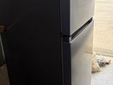 a black refrigerator sitting in the middle of a room