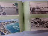 a person holding a book open to show pictures of a city