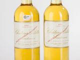 deux bouteilles de vin blanc posées l'une à côté de l'autre sur une surface blanche